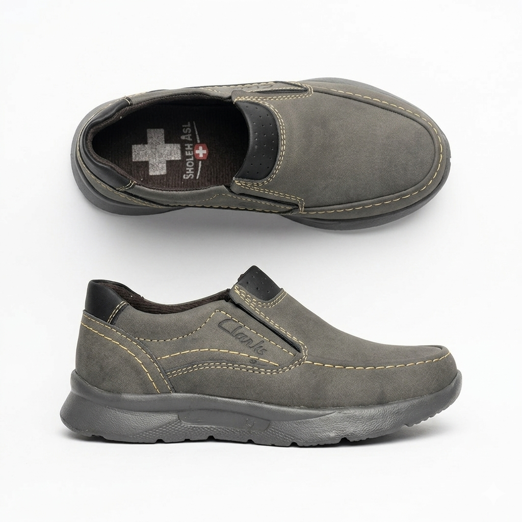 کفش راحتی روزمره مردانه طرح Clarks رنگ طوسی نوبوک با دوخت های تزیینی کرم روی پس زمینه سفید⁠